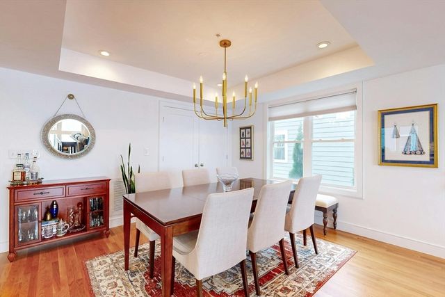 a view of a dining room with furniture a chandelier and wooden floor