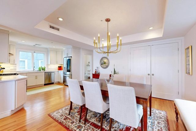 a view of a dining room and livingroom with furniture wooden floor a rug a rug a chandelier