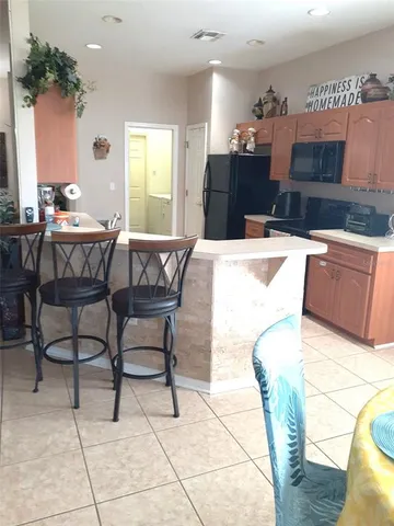 a kitchen with stainless steel appliances kitchen island granite countertop a table and chairs in it