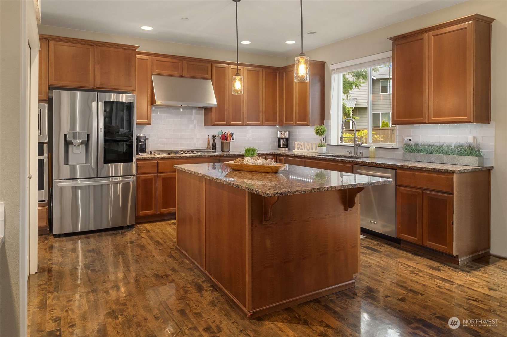 3215 217th Place Southeast Bothell, WA 98021 - Photo 12 of 30 a kitchen with stainless steel appliances granite countertop a sink a stove a refrigerator and island with wooden floor