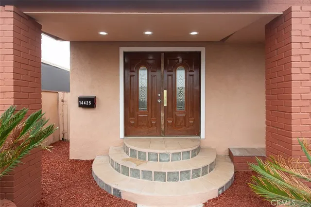 a view of a hallway with wooden floor and a potted plant