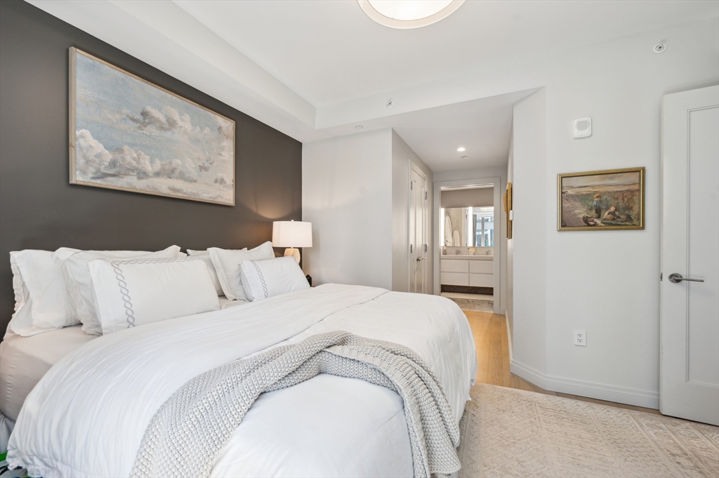 133 Seaport Boulevard, Unit 823 Boston, MA 02210 - Photo 11 of 31 a large bed sitting in a bedroom and painting on the wall