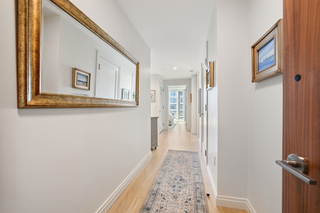 133 Seaport Boulevard, Unit 823 Boston, MA 02210 - Photo 22 of 31 a view of a hallway with wooden floor and a bathroom