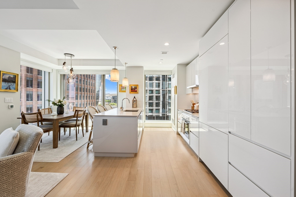 133 Seaport Boulevard, Unit 823 Boston, MA 02210 - Photo 4 of 31 a large open kitchen with a large window and stainless steel appliances