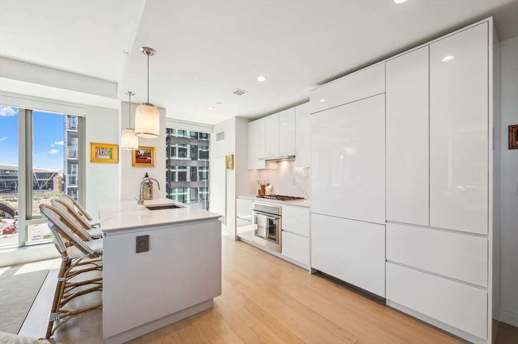 133 Seaport Boulevard, Unit 823 Boston, MA 02210 - Photo 6 of 31 a kitchen with white cabinets and white appliances