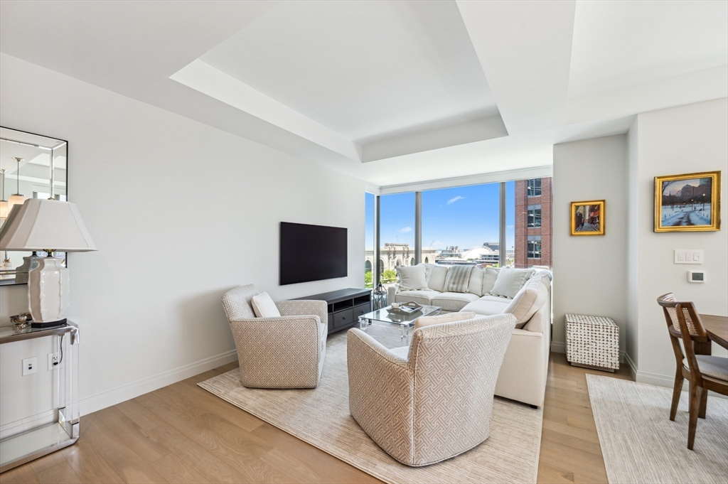 133 Seaport Boulevard, Unit 823 Boston, MA 02210 - Photo 8 of 31 a living room with furniture a lamp and a flat screen tv