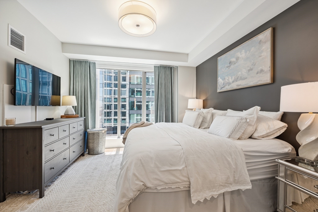 133 Seaport Boulevard, Unit 823 Boston, MA 02210 - Photo 10 of 31 a spacious bedroom with a bed and wooden floor