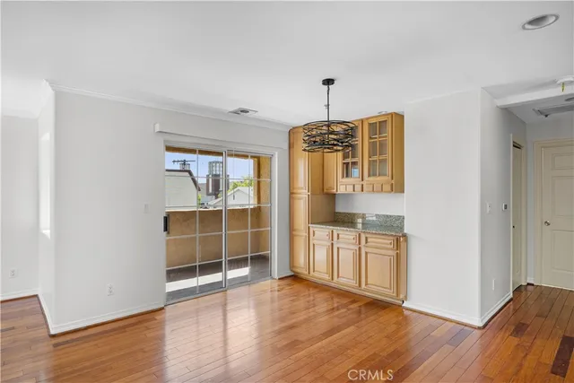 an empty room with wooden floor and cabinet