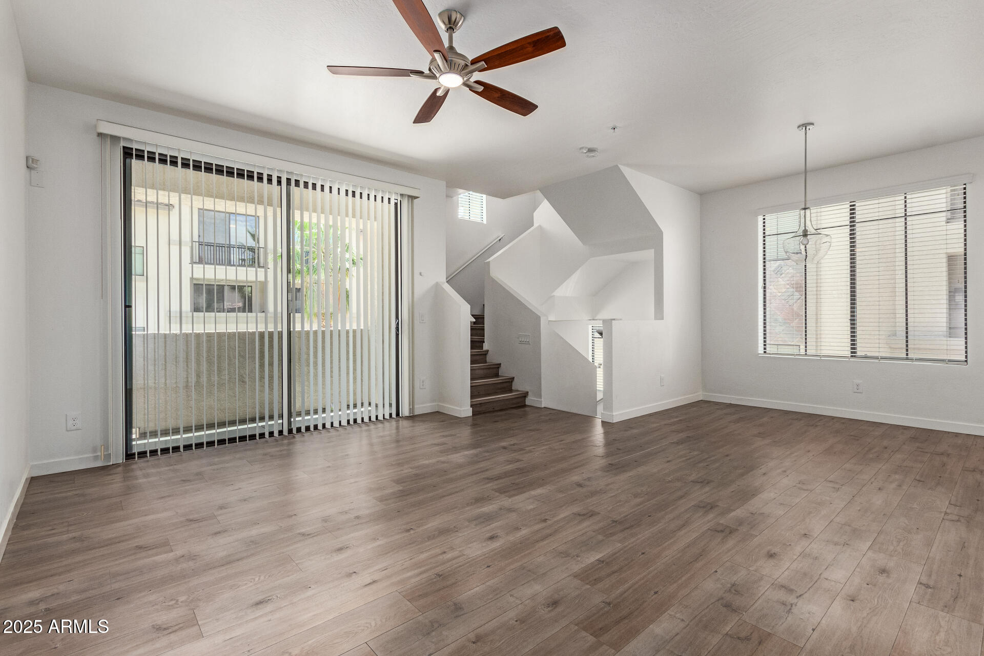 2315 North 52nd Street, Unit 144 Phoenix, AZ 85008 - Photo 6 of 28 an empty room with wooden floor and windows