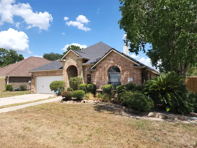 a front view of a house with yard and parking