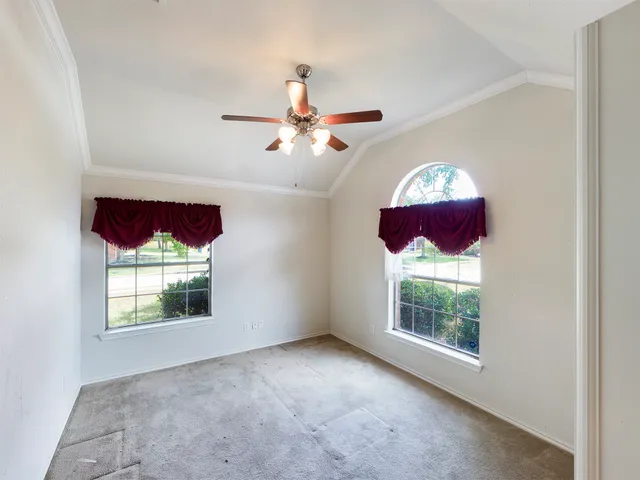 an empty room with windows and fan