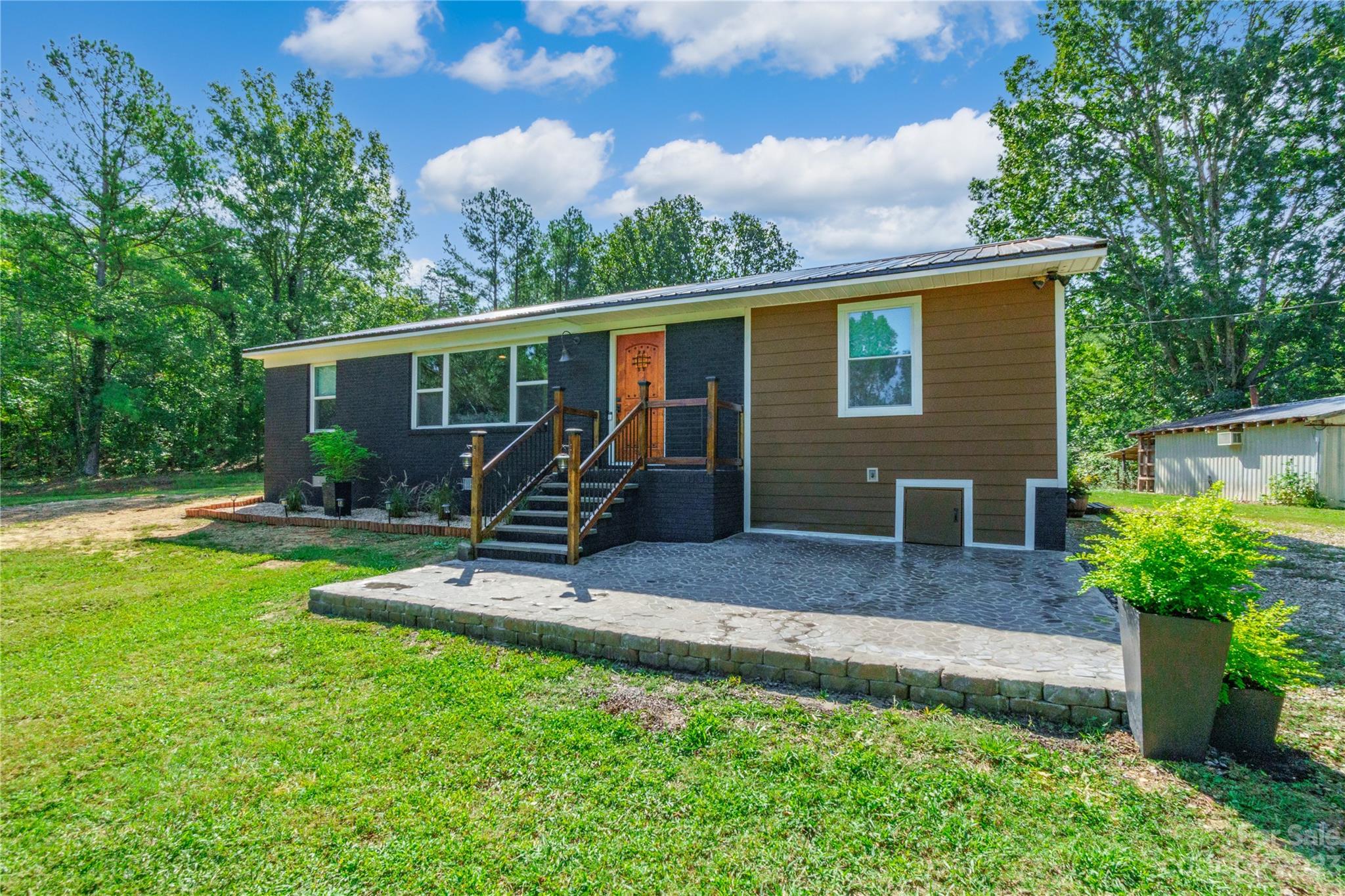 177 State Rd S-29-70 Lancaster, SC 29720 - Photo 4 of 30 a view of a house with backyard sitting area and garden