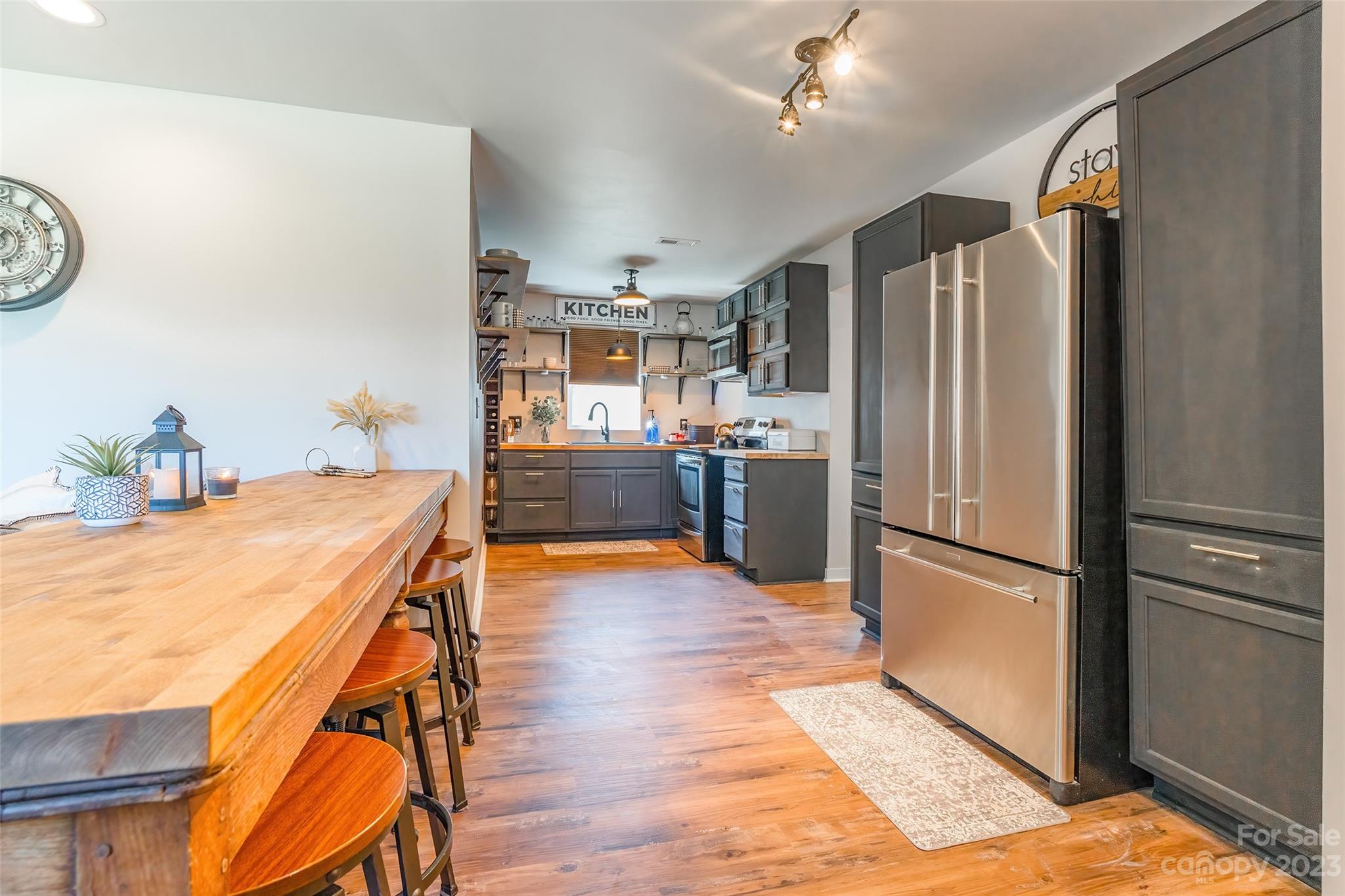 177 State Rd S-29-70 Lancaster, SC 29720 - Photo 6 of 30 a kitchen with stainless steel appliances a refrigerator a stove a sink dishwasher and a dining table with wooden floor