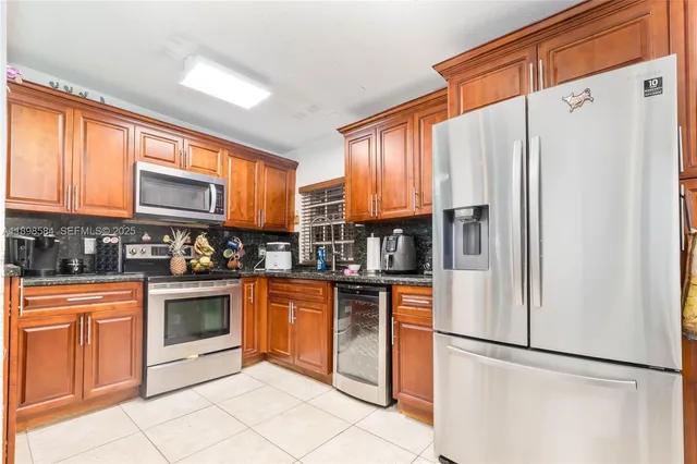 a kitchen with stainless steel appliances granite countertop a refrigerator and a stove top oven