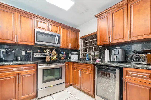 a kitchen with stainless steel appliances granite countertop a stove sink and cabinets
