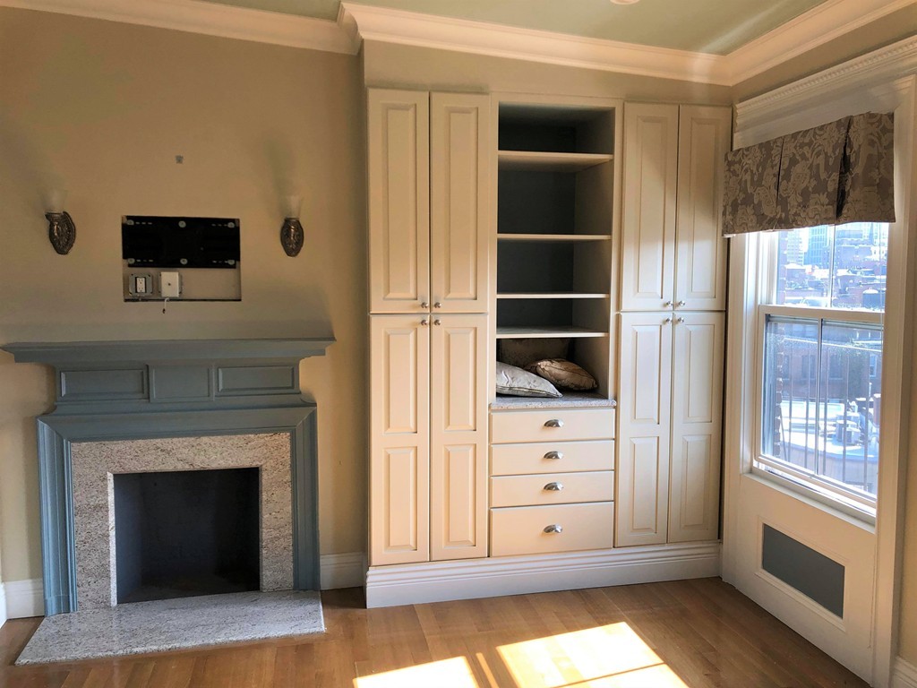 a view of an empty room with cabinet and a fireplace