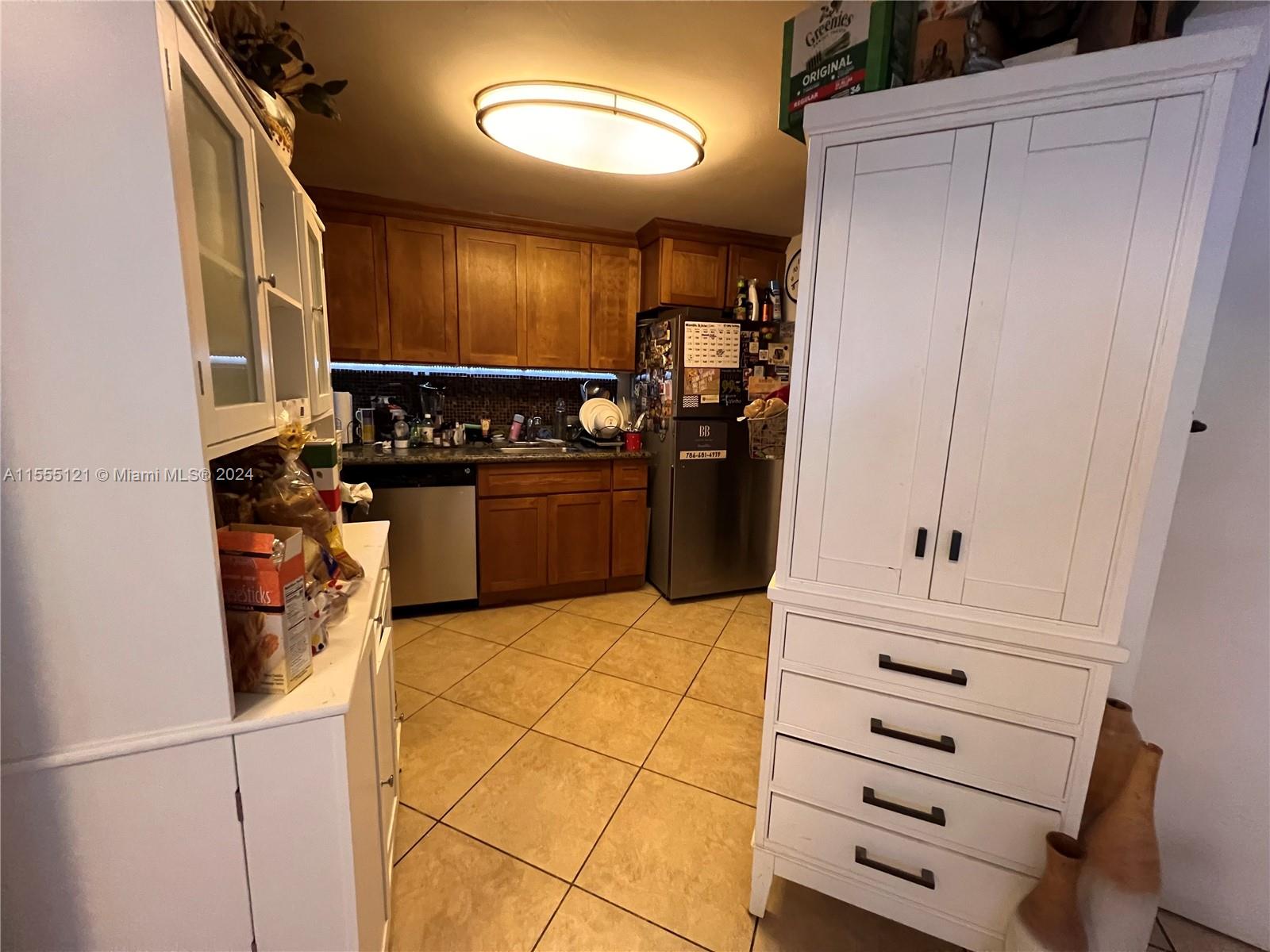 a kitchen with granite countertop cabinets and refrigerator
