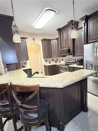 a kitchen with granite countertop a sink stainless steel appliances and cabinets