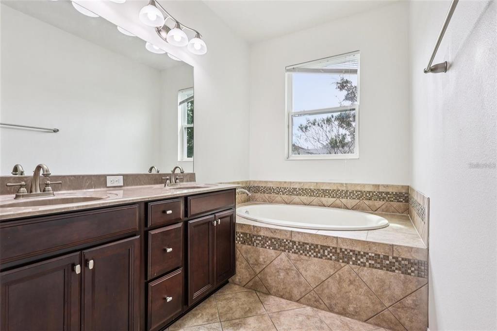 1126 Maumee Street Orlando, FL 32828 - Photo 15 of 21 a bathroom with a sink a toilet a mirror and shower
