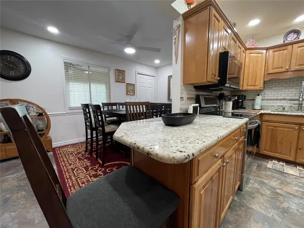 a kitchen with granite countertop a sink a stove and cabinets