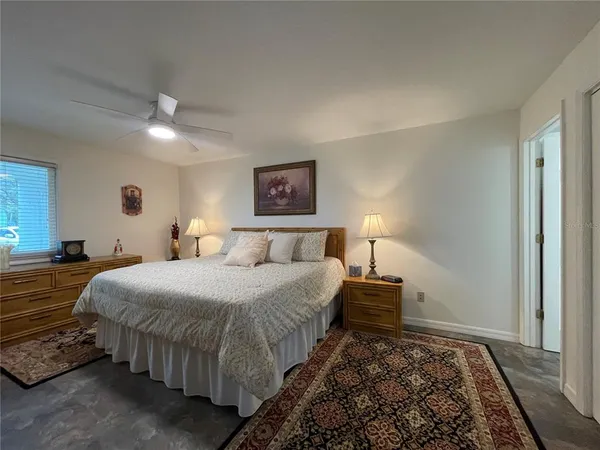 a spacious bedroom with a bed a couch and window