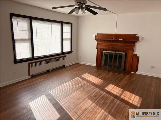 a living room with a balcony a bed and a ceiling fan