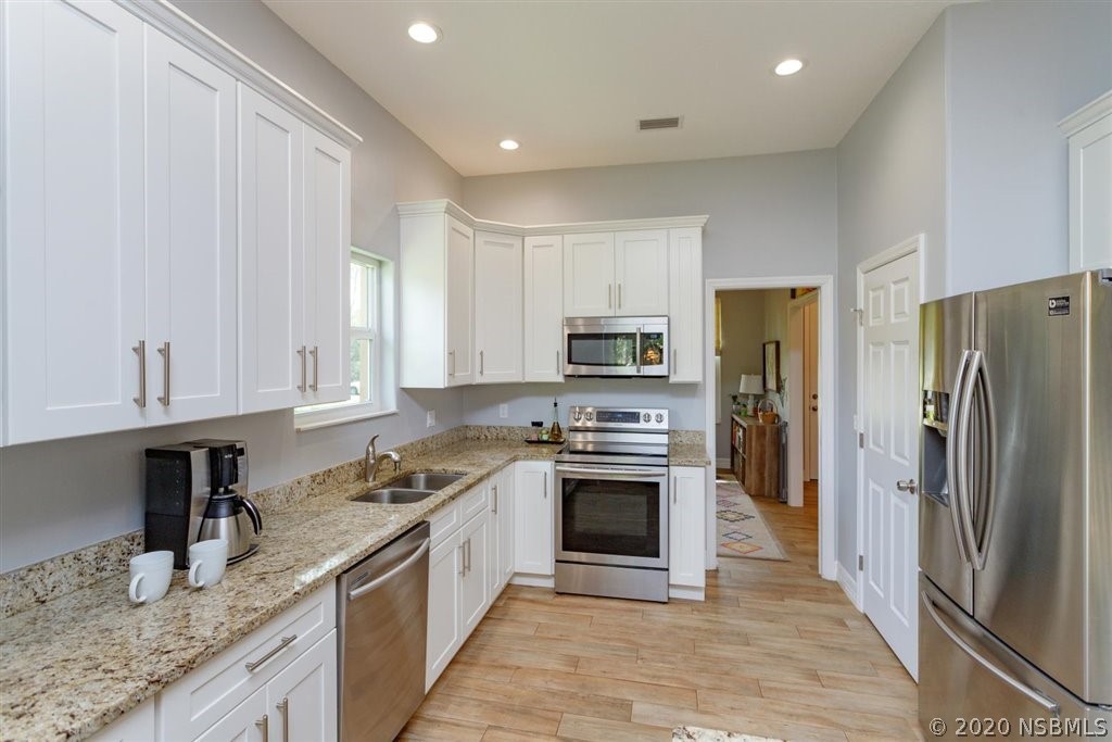 141 Poinciana Road Edgewater, FL 32141 - Photo 7 of 26 a kitchen with stainless steel appliances granite countertop a refrigerator sink and stove