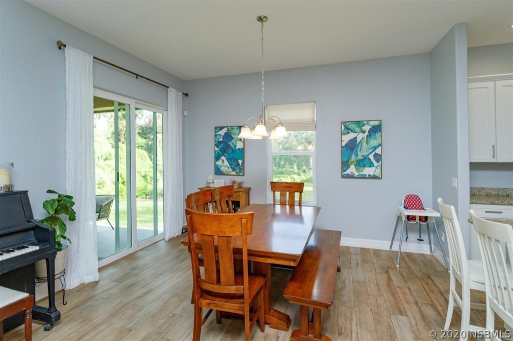 141 Poinciana Road Edgewater, FL 32141 - Photo 8 of 26 a dining room with furniture a chandelier and wooden floor