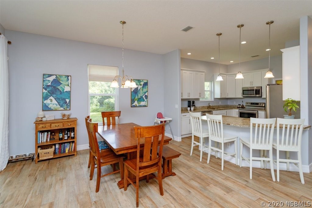 141 Poinciana Road Edgewater, FL 32141 - Photo 9 of 26 a view of a dining room with furniture and a wooden floor