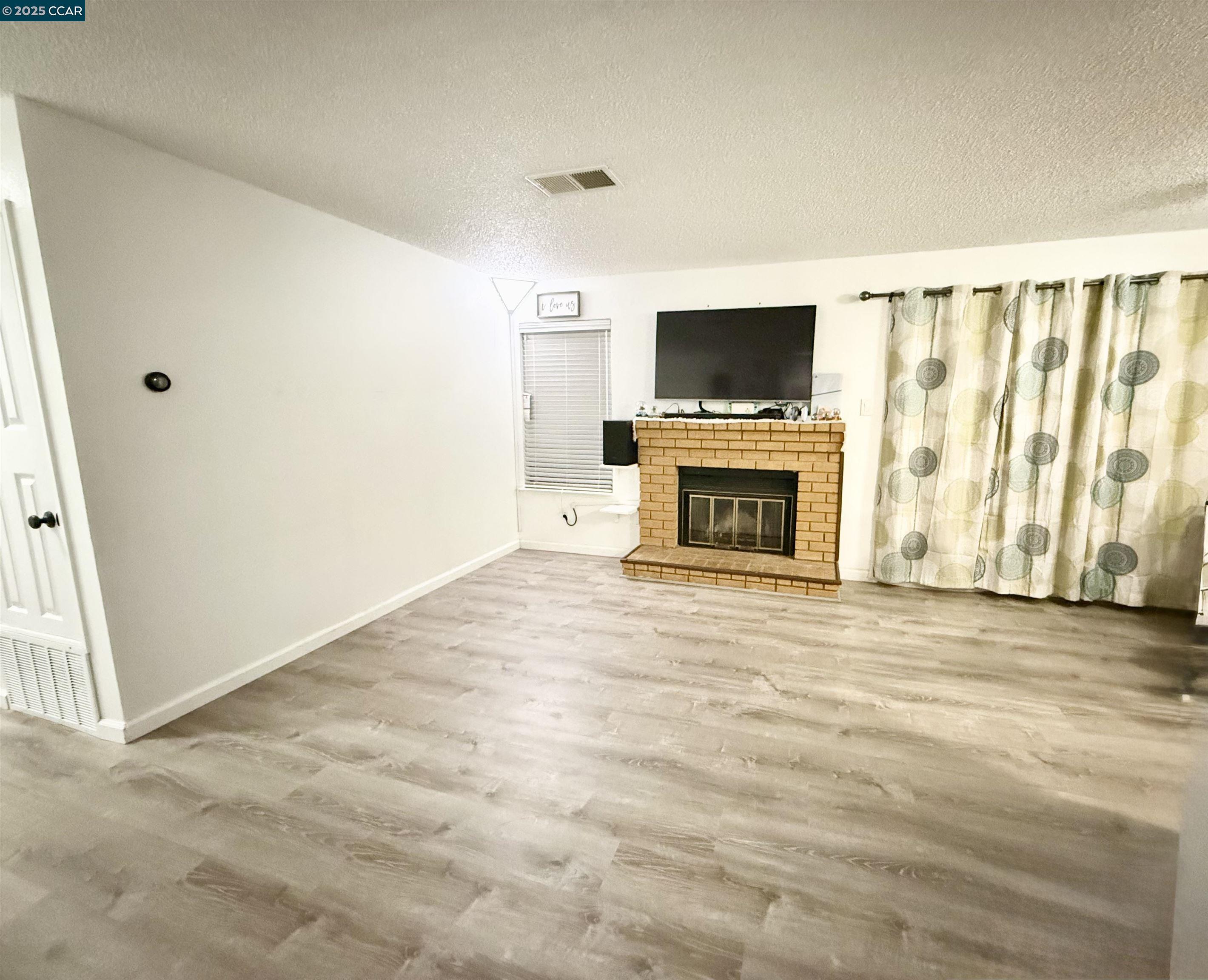 405 Weymouth Hercules, CA 94547 - Photo 5 of 21 a view of empty room with a flat screen tv and a fireplace