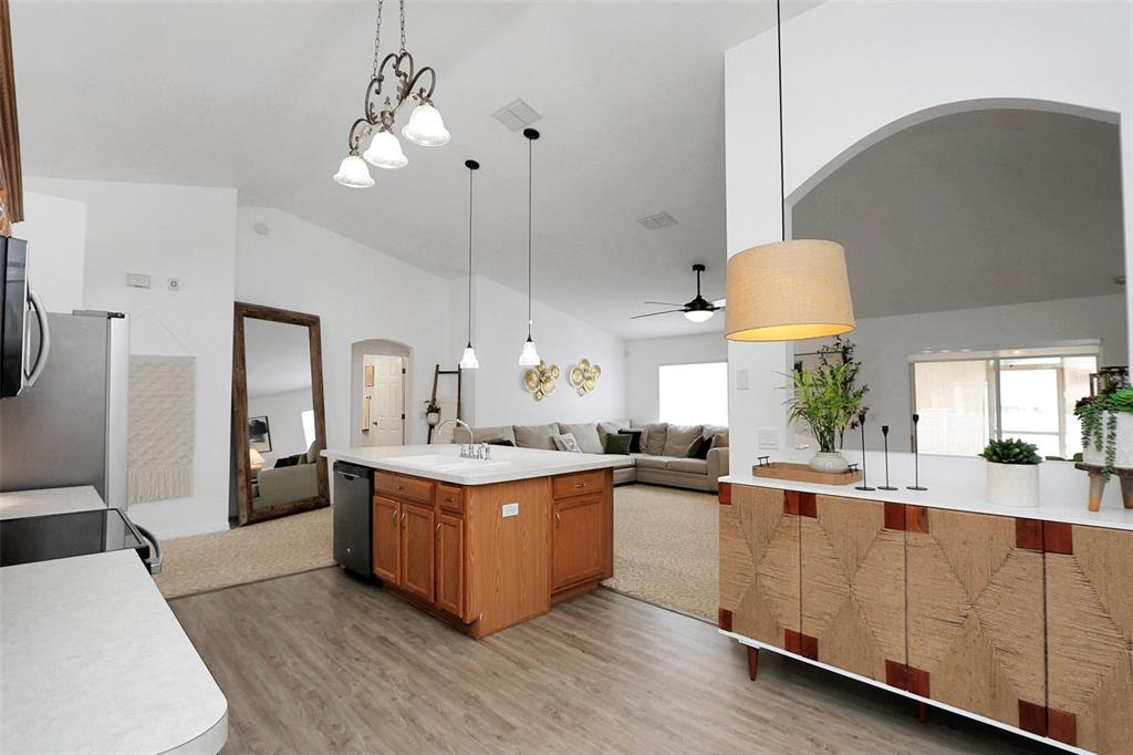 10648 Southwest 38th Avenue Ocala, FL 34476 - Photo 17 of 52 a kitchen with stainless steel appliances a sink a stove top oven a counter space and cabinets