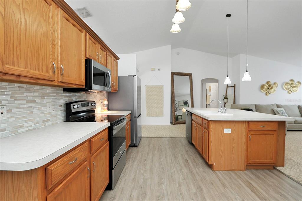 10648 Southwest 38th Avenue Ocala, FL 34476 - Photo 18 of 52 a kitchen with stainless steel appliances granite countertop wooden cabinets a sink dishwasher a stove and a refrigerator