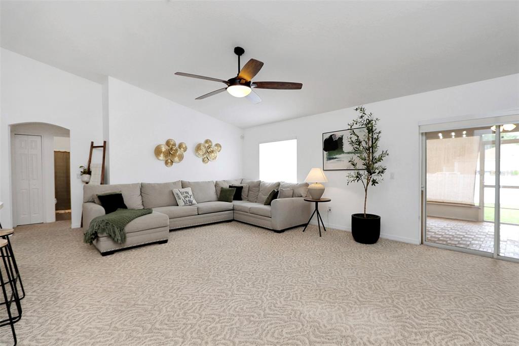 10648 Southwest 38th Avenue Ocala, FL 34476 - Photo 19 of 52 a living room with furniture and a chandelier