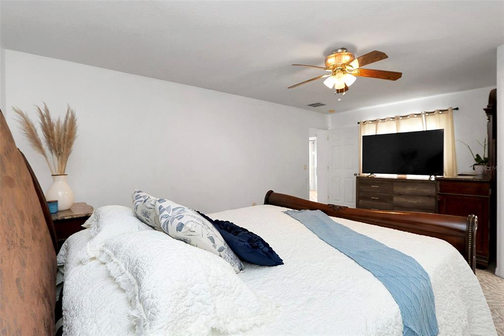 10648 Southwest 38th Avenue Ocala, FL 34476 - Photo 29 of 52 a bedroom with a bed and a flat screen tv