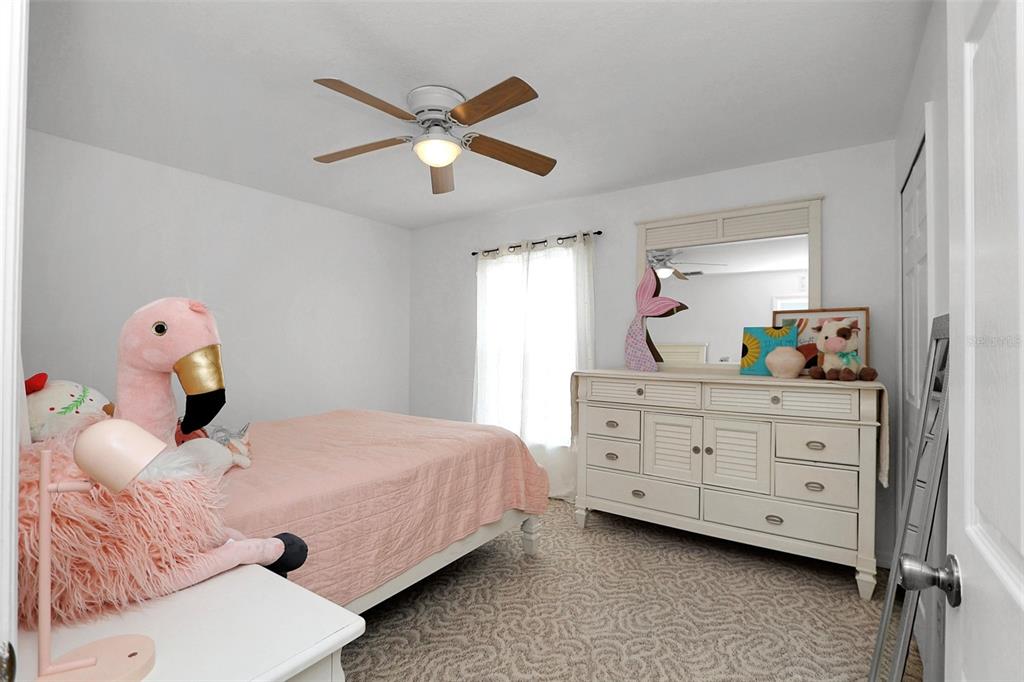 10648 Southwest 38th Avenue Ocala, FL 34476 - Photo 34 of 52 a bedroom with a bed and a chandelier