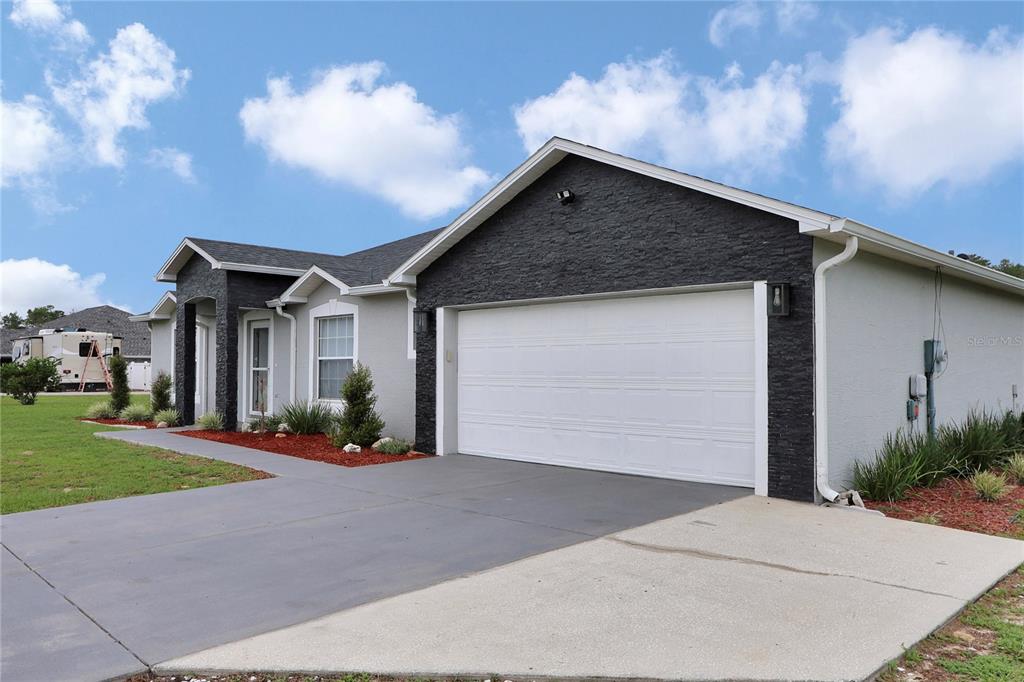 10648 Southwest 38th Avenue Ocala, FL 34476 - Photo 42 of 52 a front view of a house with a yard and garage