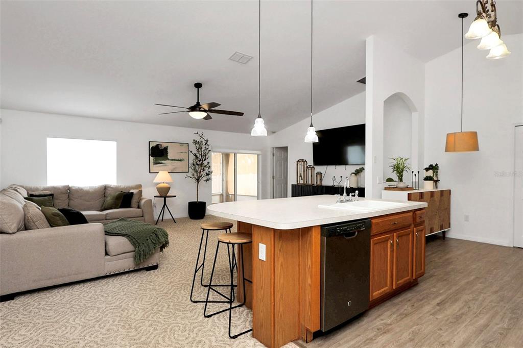 10648 Southwest 38th Avenue Ocala, FL 34476 - Photo 10 of 52 a large kitchen with stainless steel appliances kitchen island granite countertop a sink and a living room view