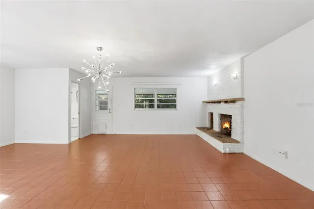 a view of empty room with fireplace and windows