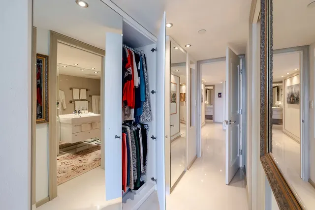 a view of a hallway with bathroom and wooden floor