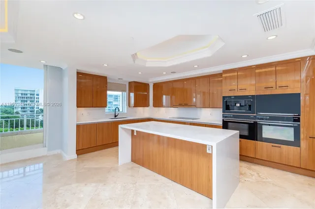 a kitchen with stainless steel appliances kitchen island granite countertop a stove and a sink