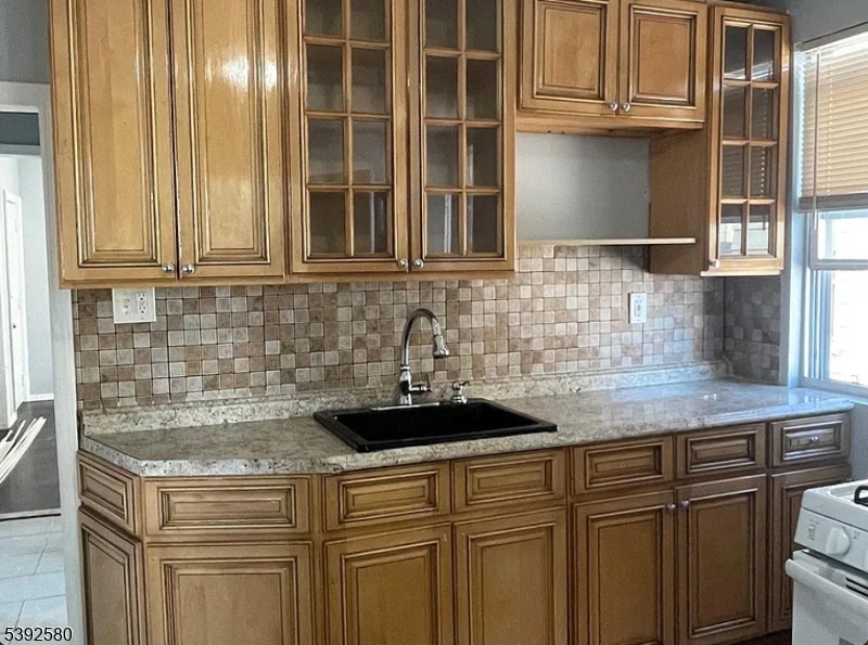 a kitchen with granite countertop a sink and cabinets