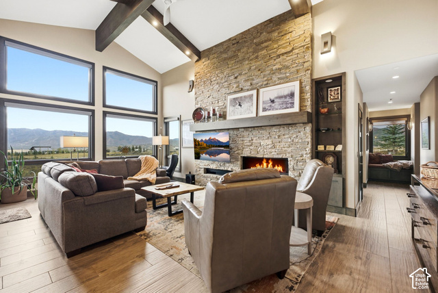 1130 Pace Road Park City, UT 84098 - Photo 3 of 73 Vaulted ceiling with exposed wood beams, stone-clad fireplace, built-in shelving, wood-finish flooring, and large picture windows