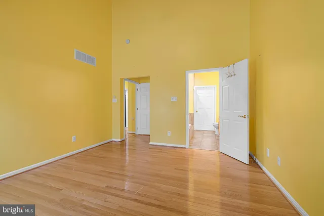 a view of a hallway with wooden floor and entryway