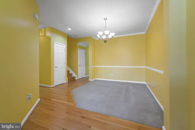 a view of a room with wooden floor and chandelier