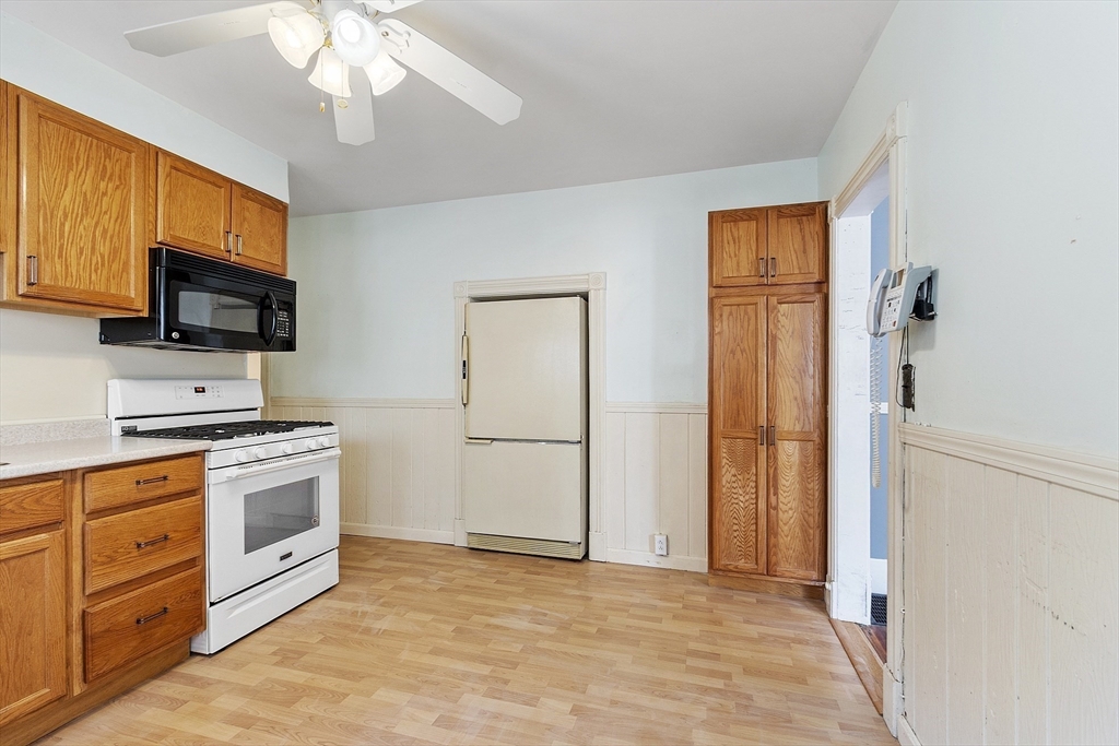 111 Central Street Concord, MA 01742 - Photo 12 of 42 a kitchen with stainless steel appliances granite countertop a stove top oven a refrigerator a sink and dishwasher with white cabinets