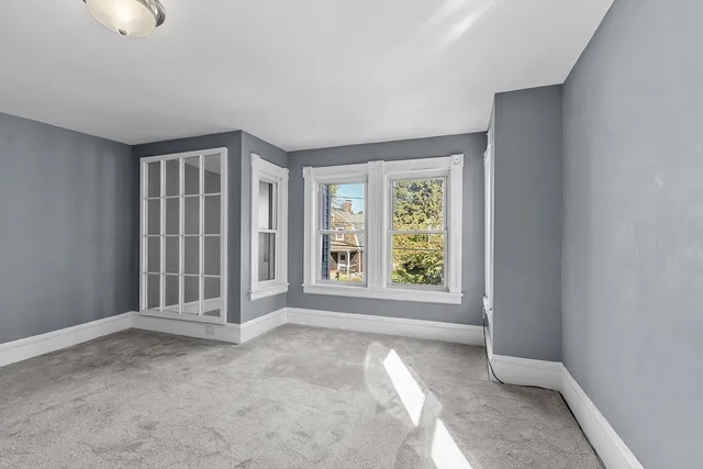 a view of an empty room with window and closet area