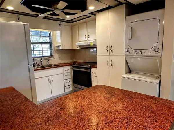 a kitchen with a refrigerator sink and cabinets