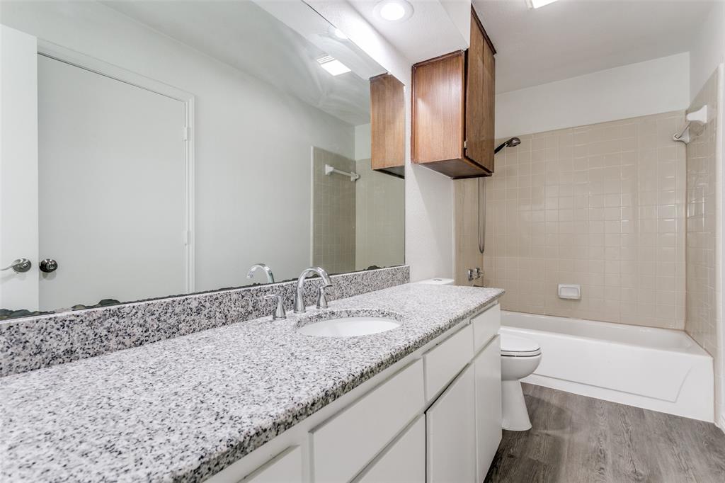 2121 Stone Moss Lane Grapevine, TX 76051 - Photo 12 of 12 Loft ensuite full bathroom with granite vanity, bath/shower combination and wood cabinets