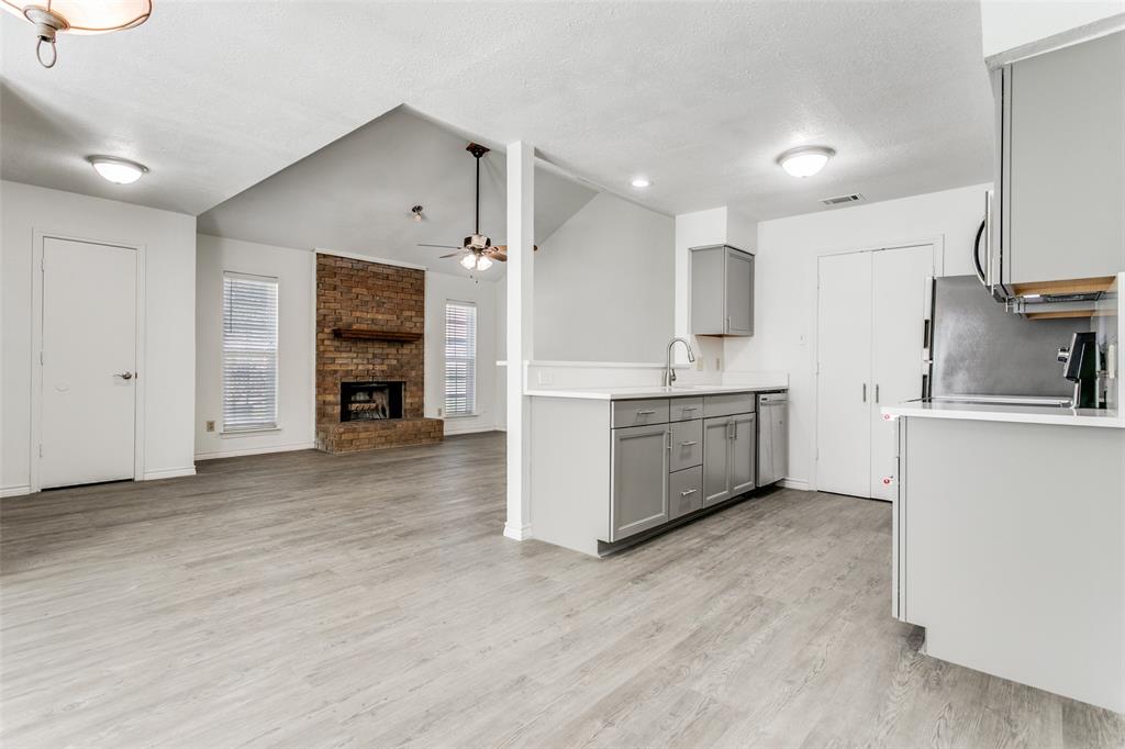 2121 Stone Moss Lane Grapevine, TX 76051 - Photo 2 of 12 Open Concept - From the dining area you can see into the kitchen with new quartz countertops and eat-in bar, new stainless-steel appliances, overlooking into entryway and living room with fireplace and cathedral ceilings.