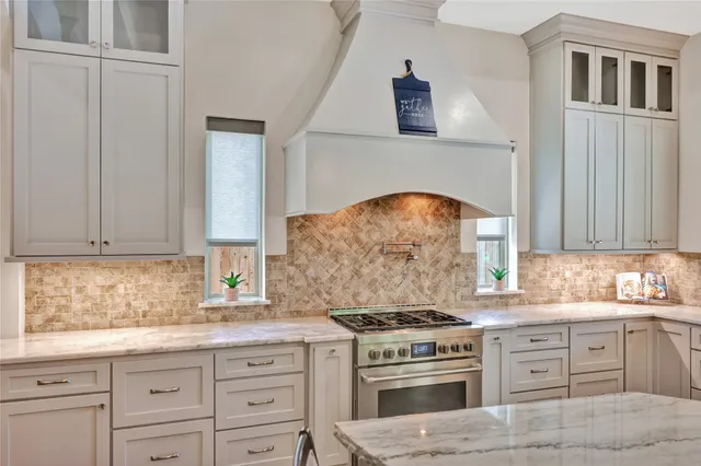 a kitchen with granite countertop a stove sink and cabinets